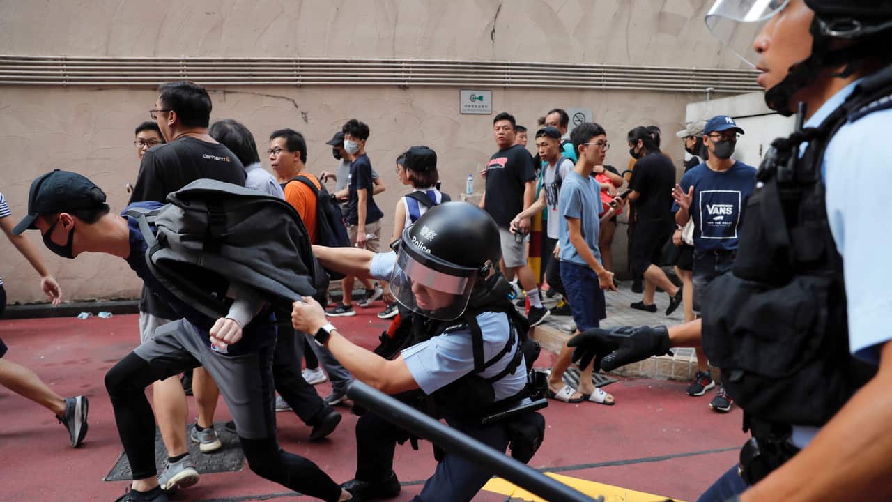 Police detain a young men after fights broke out between pro-China supporters and anti-government protesters at Amoy Plaza in the Kowloon Bay district.
