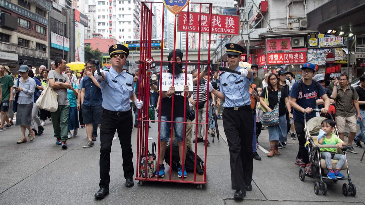 Pro-democracy activists dressed as mainland Chinese policemen take part in a march against a proposed extradition law in Hong Kong.