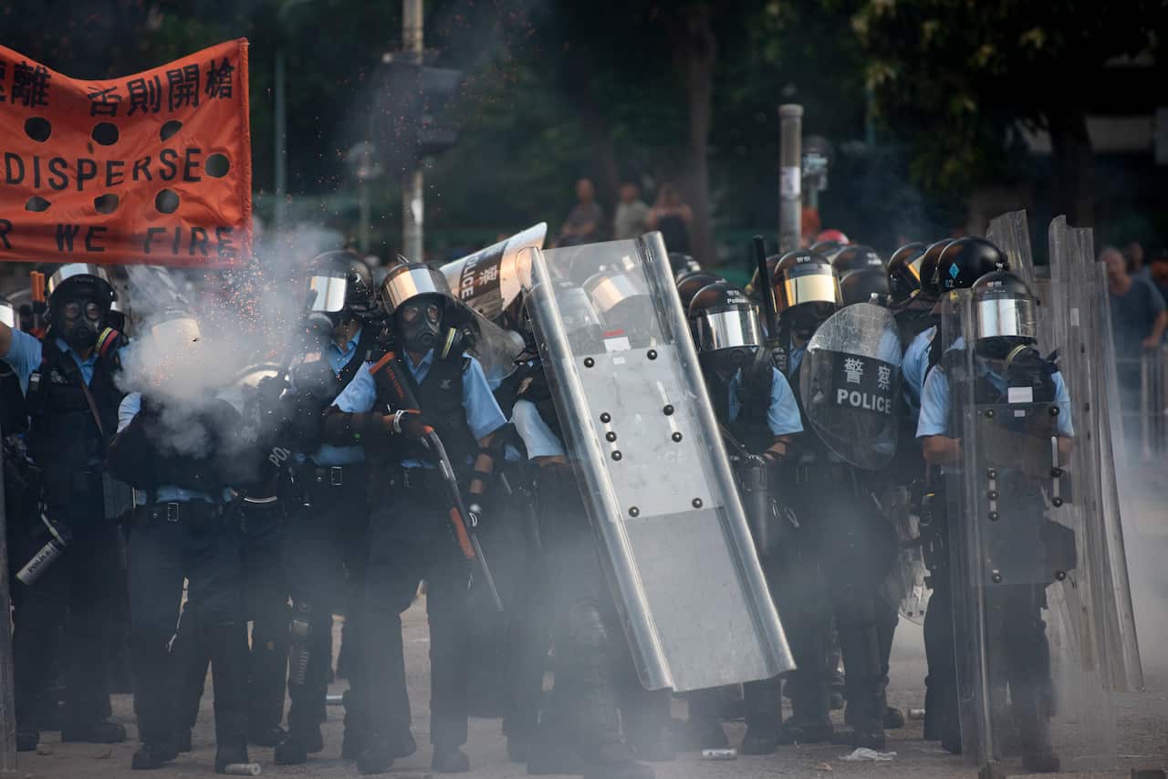 Riot police officers fire tear gas and rubber bullets towards the anti-government protesters during the demonstration.