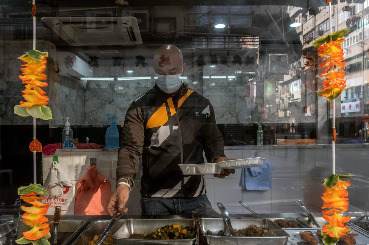Sushil Newa, the owner of a Nepalese restaurant in the lockdown zone in Jordan, Hong Kong, serves up an order on Jan. 25, 2021.