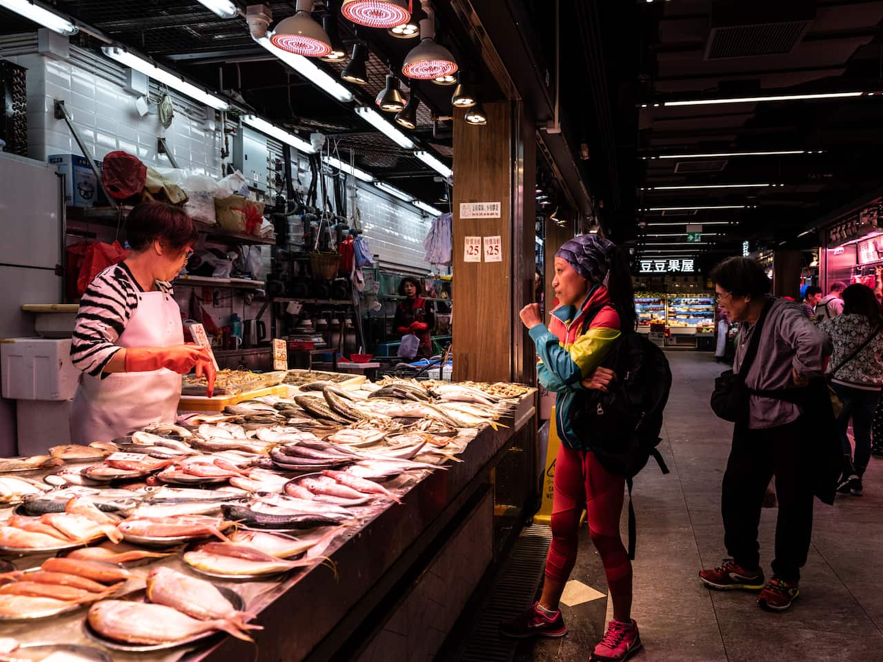Jaybie Pagirigan, a Filipina domestic worker, buys fish at a market in Hong Kong.