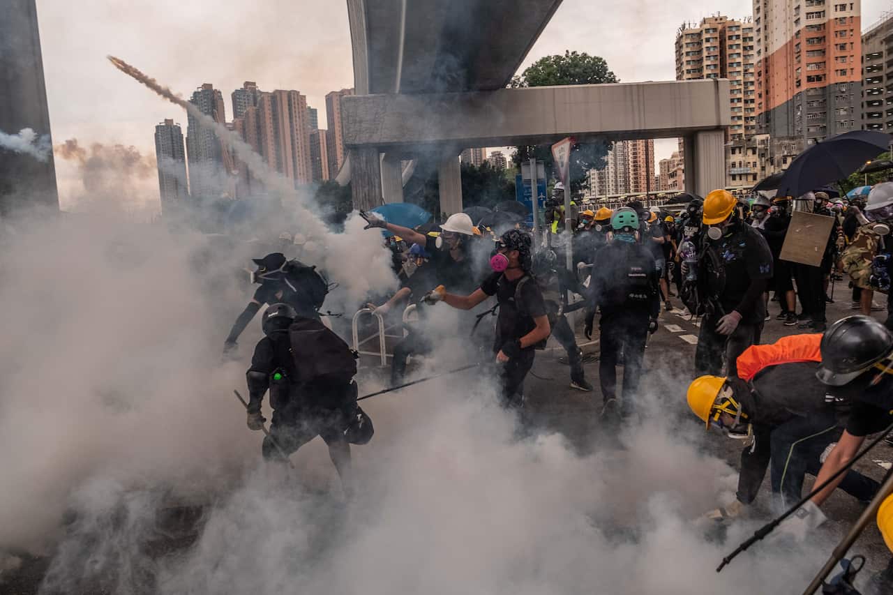 FILE -- Protesters amid tear gas fired by police during clashes in Hong Kong, July 27, 2019. On Thursday, China’s ruling Communist Party identified a novel reason for the unrest: the secret machinations of an American woman working as a diplomat in the Un