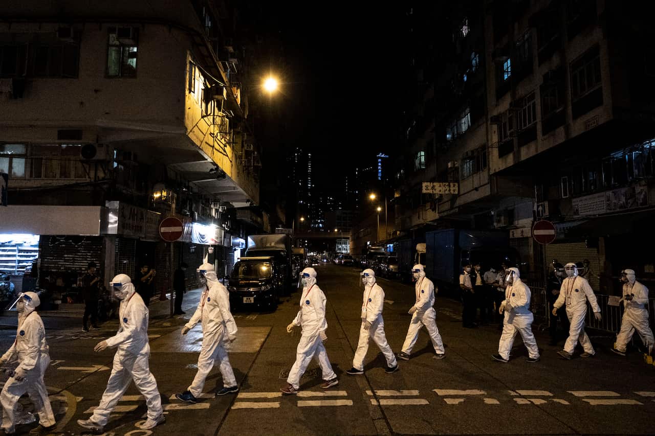 Government workers wearing personal protective equipment work in the Jordan area of Hong Kong, which is under heavy restrictions due to the pandemic.