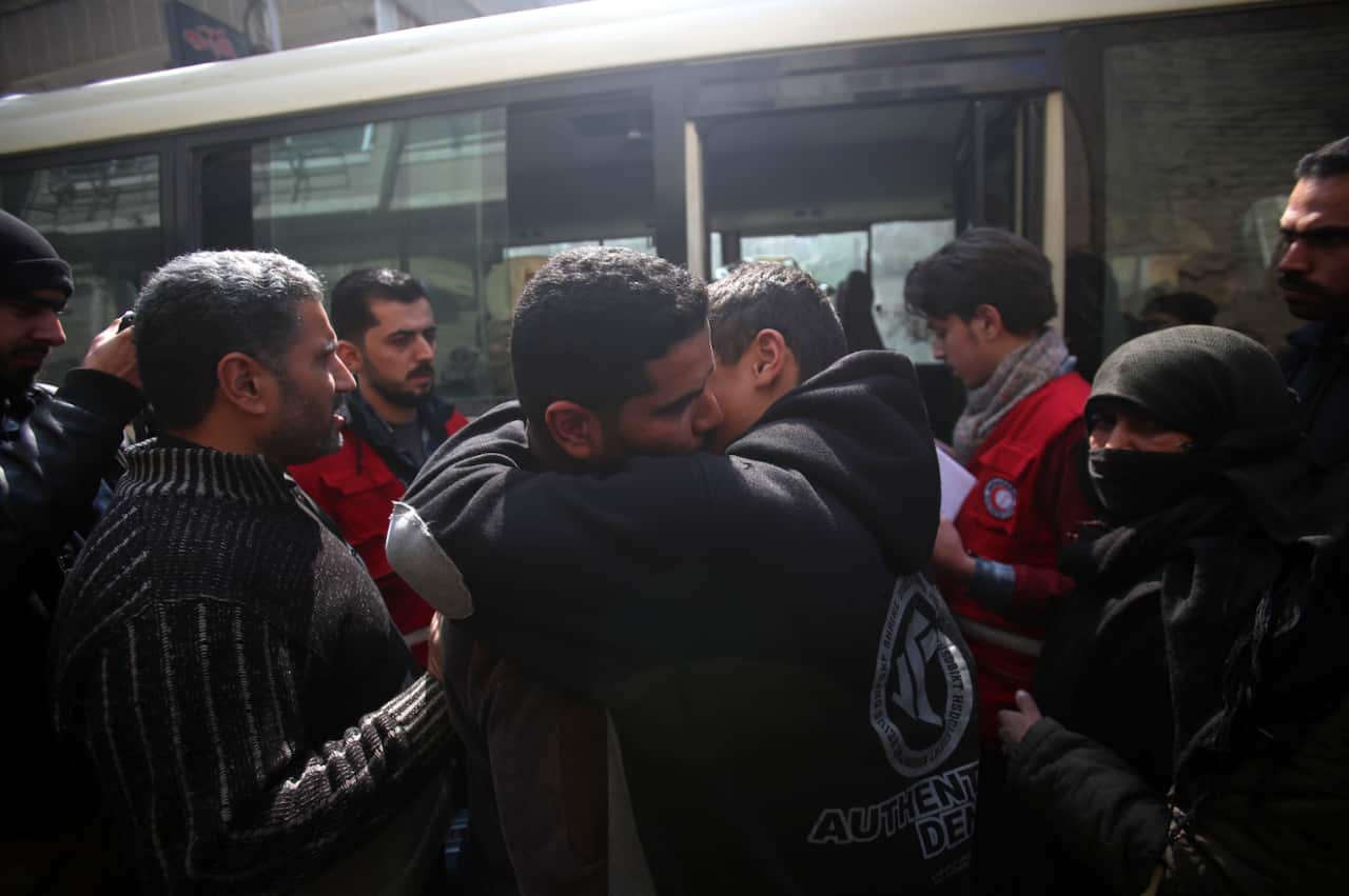 Two men hug before evacuating Eastern Ghouta. 