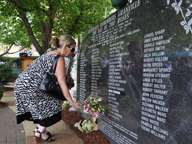 A mourner lays flowers during a memorial for the Granville disaster