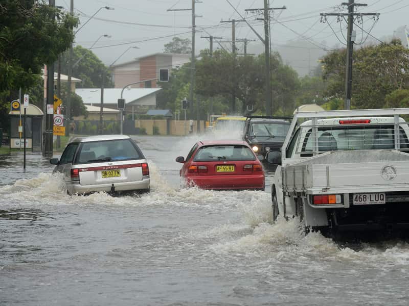 Motorists drive through a flooded waters