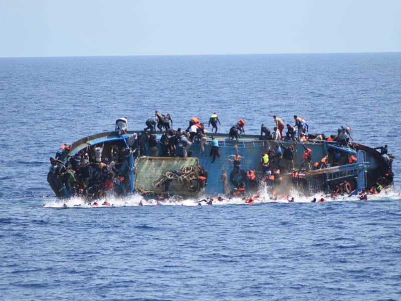 People jumping out of a boat right before it overturns
