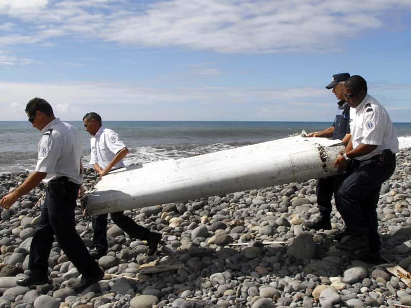 Officers carrying pieces of debris from an unidentified aircraft