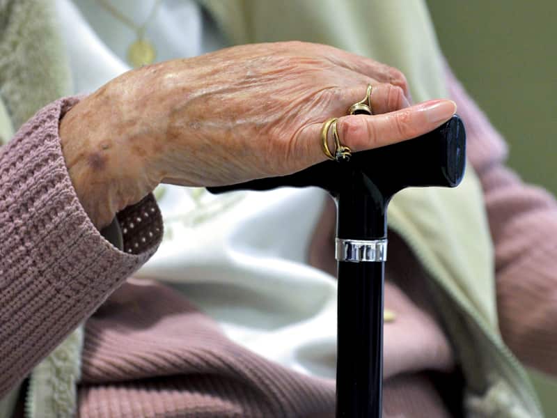 A woman uses a walking stick to assist her mobility in Canberra