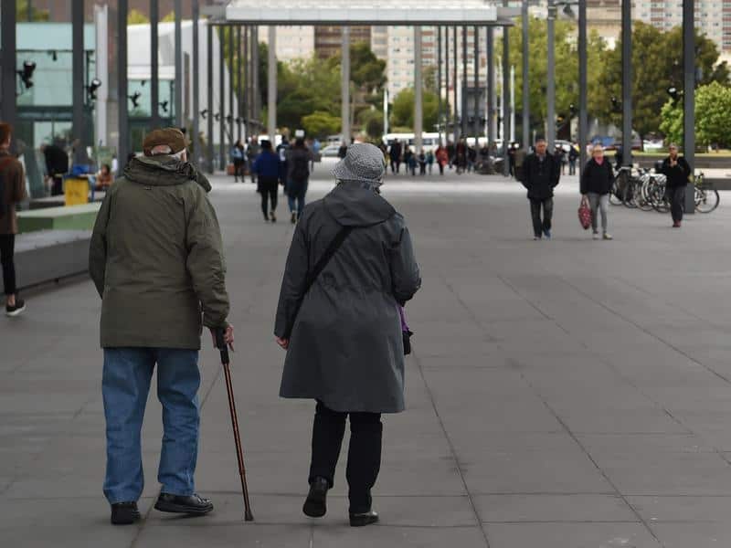 Two older people walking on street