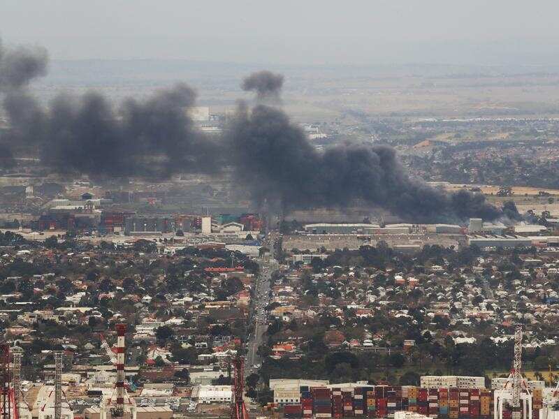 Smoke from a factory fire drifts over suburbs.