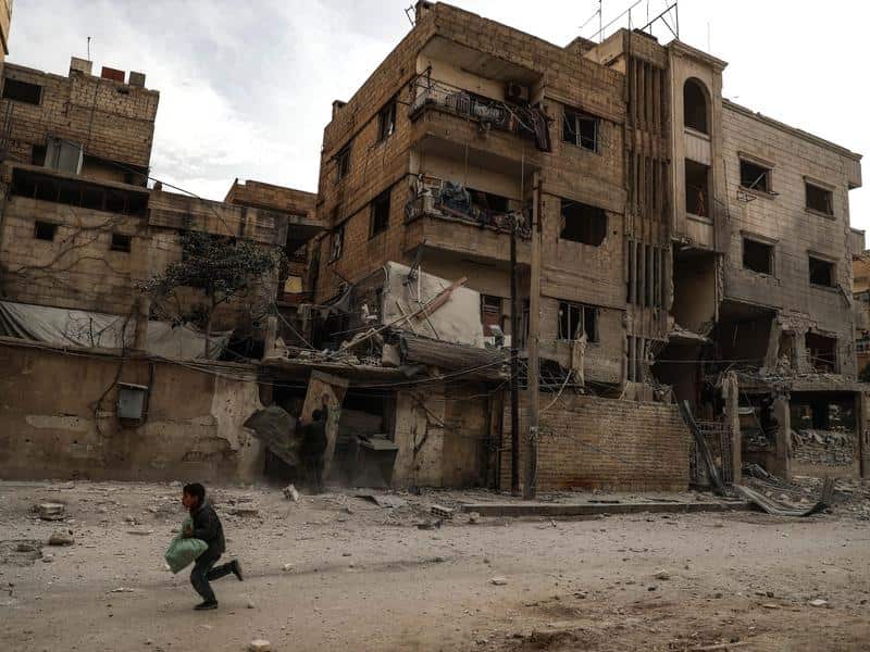 A boy runs through a bombed neighbour in Douma, eastern Ghouta.