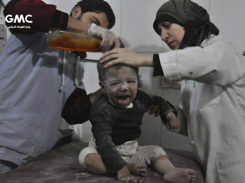 Aid workers treat a child in a makeshift hospital