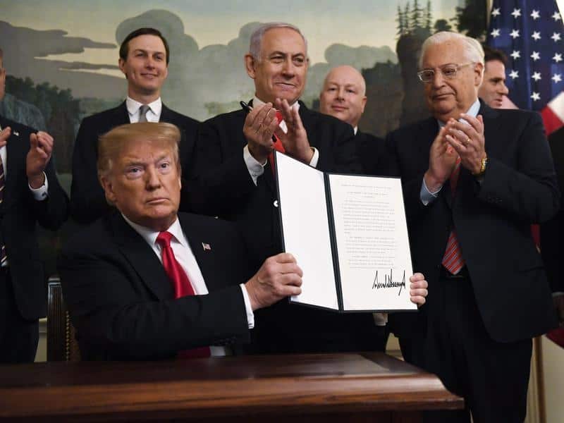 President Donald Trump holds up the signed proclamation