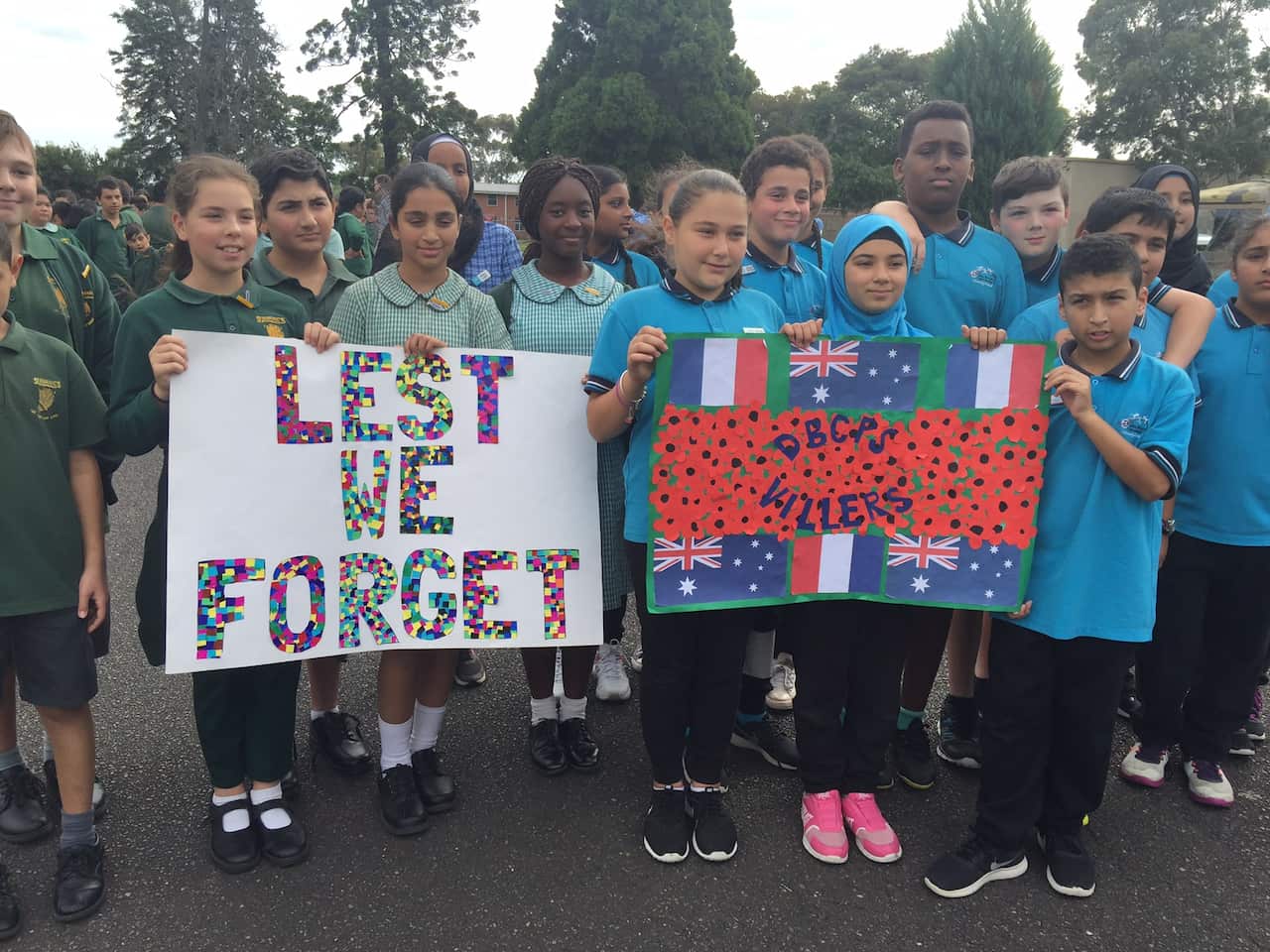 School children hold up their posters