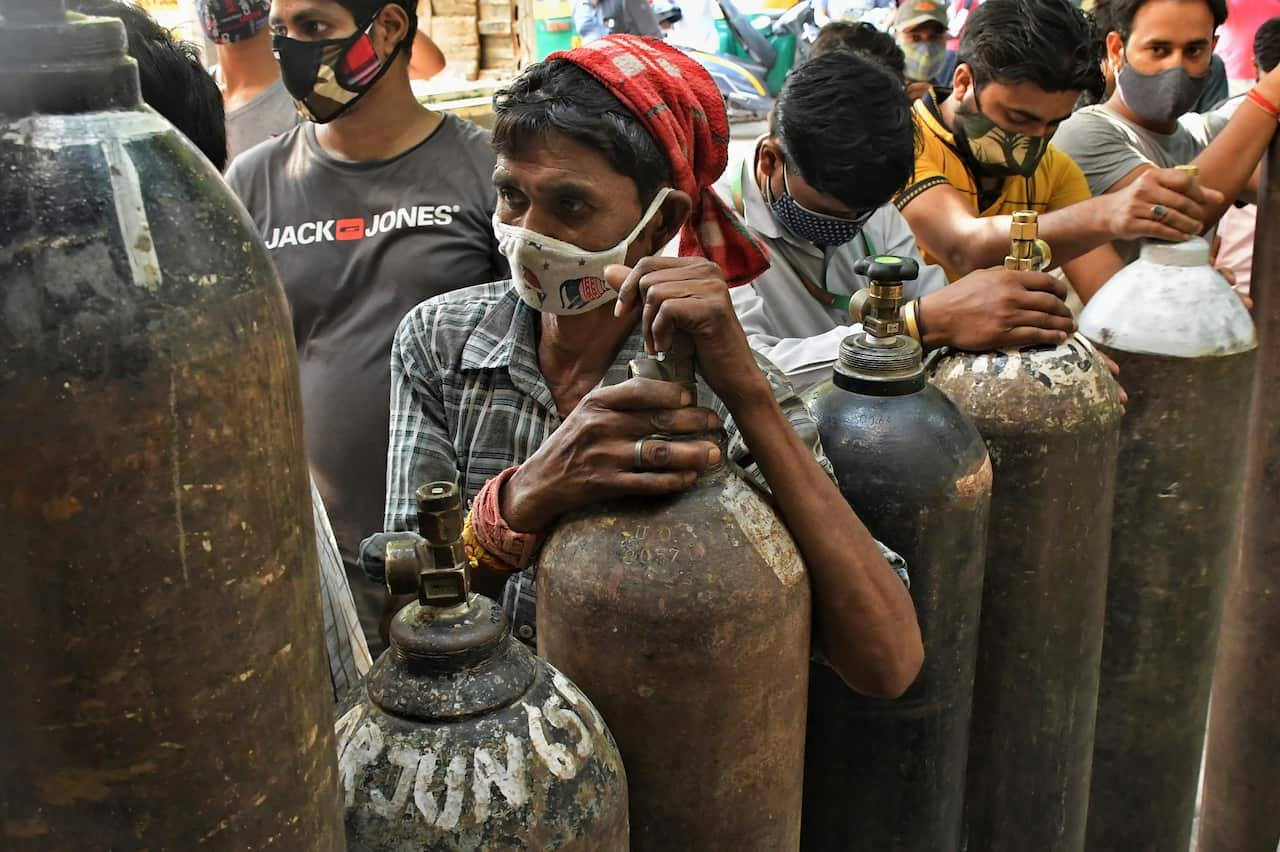 Residents wait to refill oxygen cylinders for COVID-19 patients at a gas supplier facility in New Delhi, India.