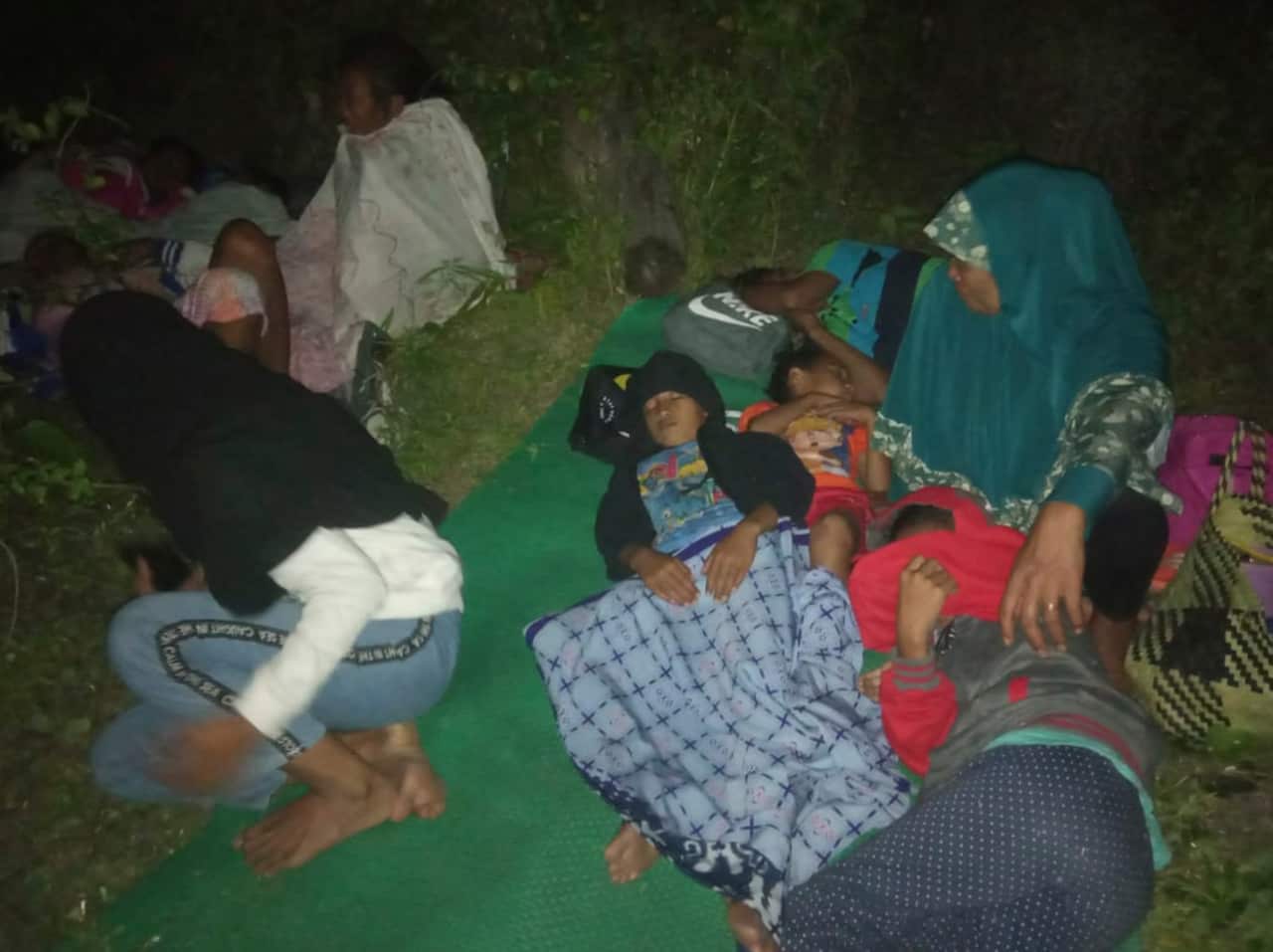 Residents sleep on the ground after leaving their homes to find higher grounds during the quake.