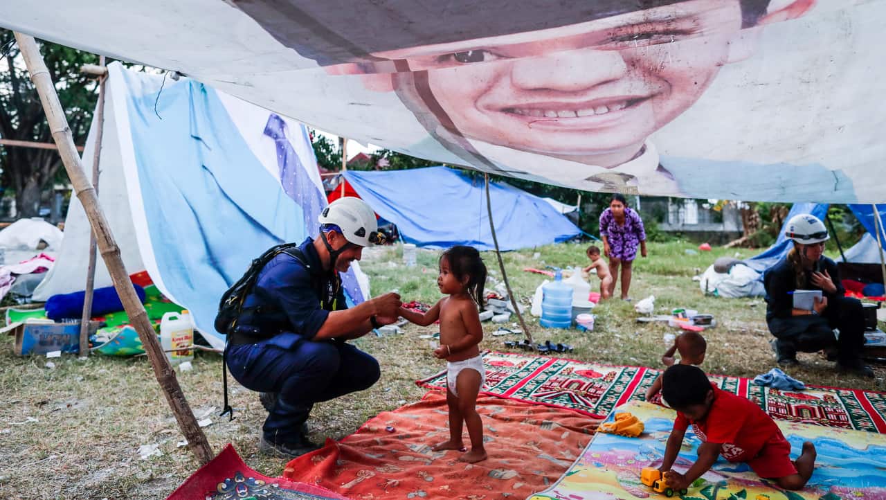 A Spanish rescue team member inspects a temporary shelter for earthquake and tsunami survivors outside the grand mosque in Palu.