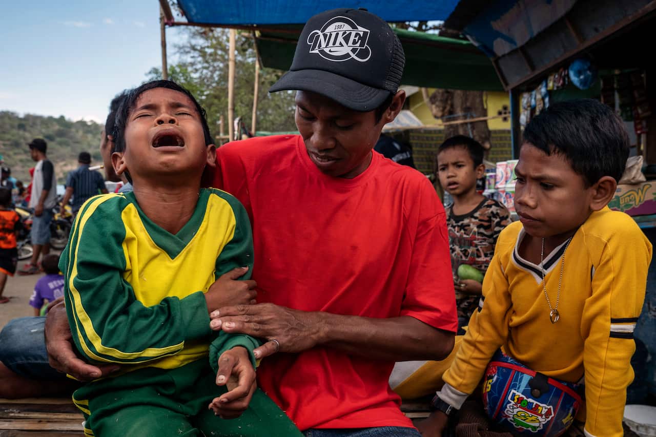 A young jockey is consoled after hurting his arm in a fall during a horse race in Bima, on the Indonesian island of Sumbawa, where child jockeys are a longstanding tradition. (Adam Dean/The New York Times)
