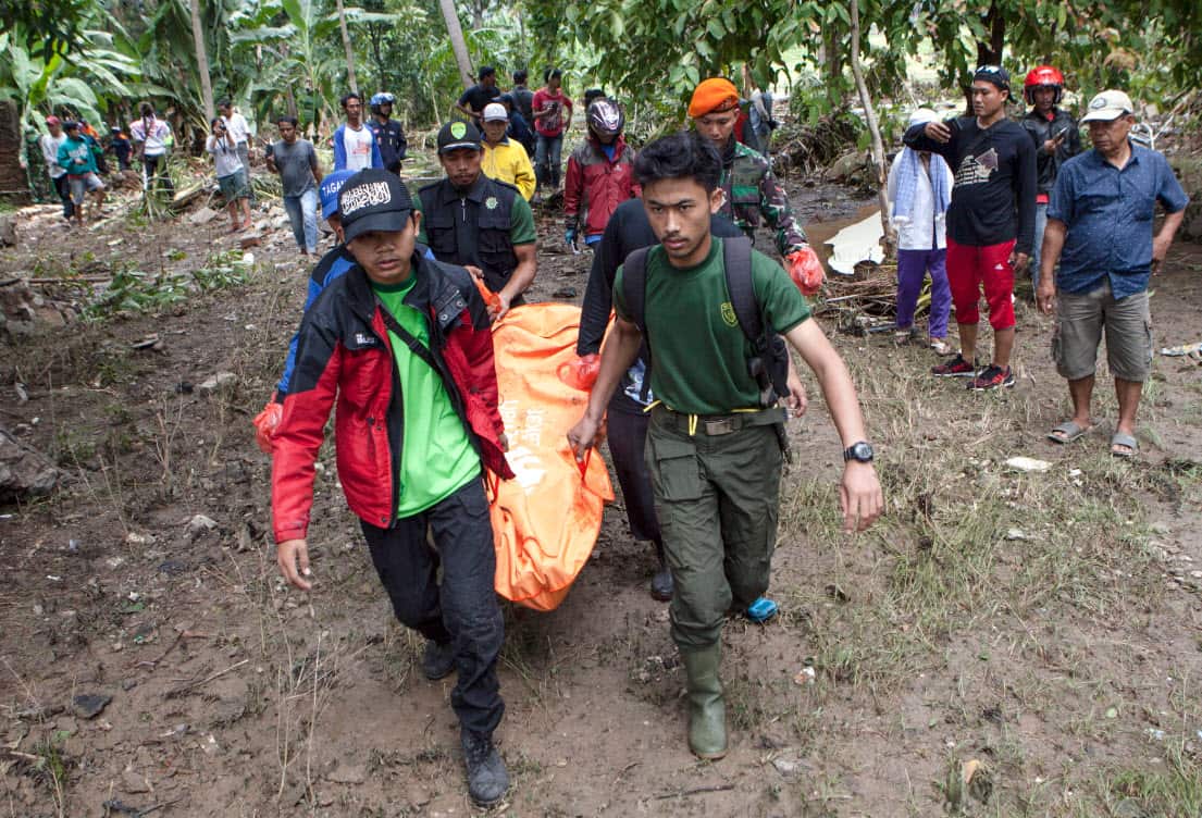 Indonesian volunteers carry a body after a tsunami on Anyer Beach in Karang Sugara village, Anyer, Banten, Indonesia, 24 December 2018 (AAP)