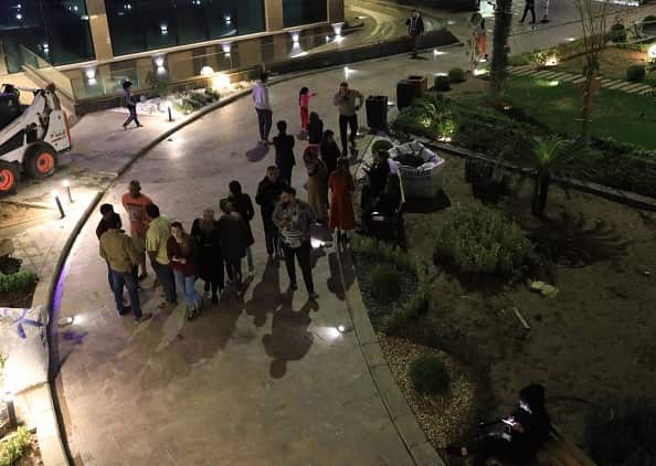 People wait outside of buildings after the 6.4 magnitude earthquake hit western Iran.