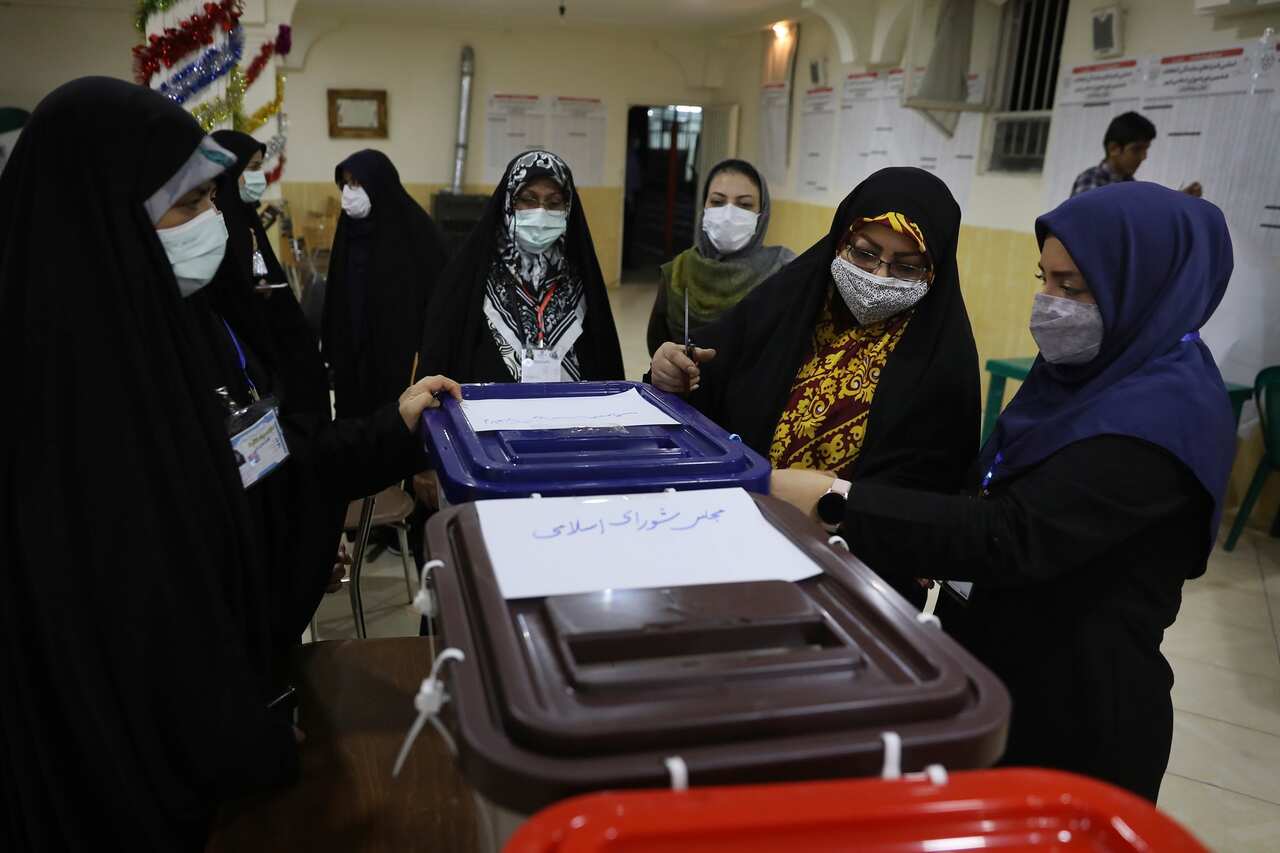 Female voters cast their ballot in Iran's presidential election.