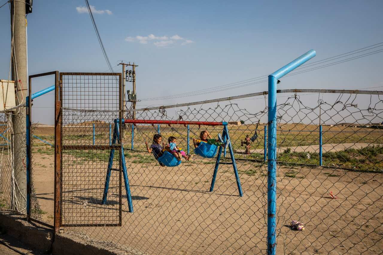 Youths play on swings at Roj Camp for the families of IS members in Kurdish-controlled northern Syria, June 23, 2018.