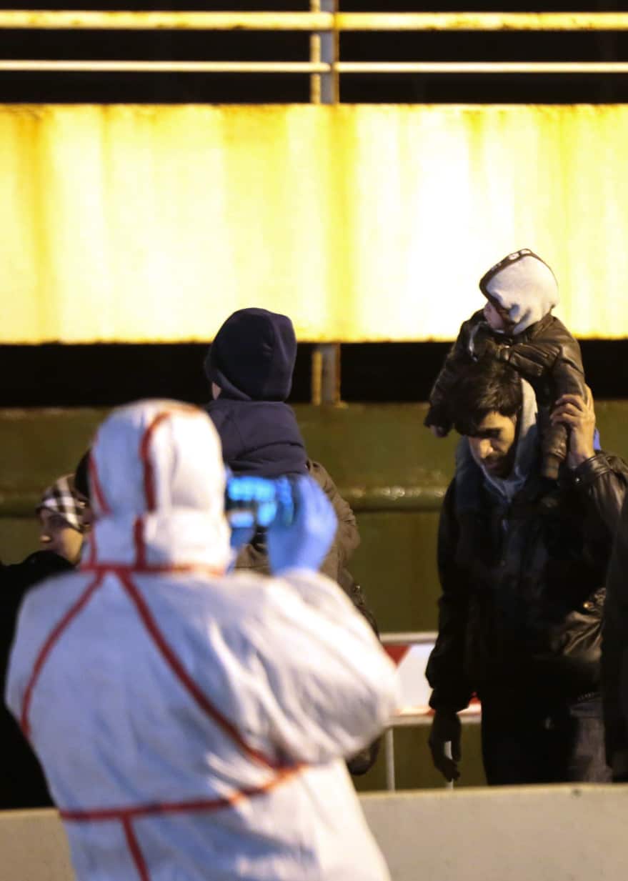 A man with a baby waits to disembark the 'ghost ship' which was abandoned at sea. Italian authorities lowered engineers and electricians onto the ship by helicopter to secure it. (AAP)