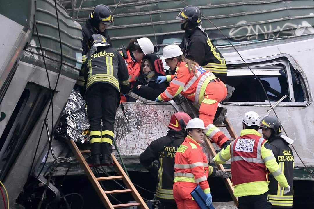 Rescuers help people after a derailed train near Milan, Italy, 25 January 2018.