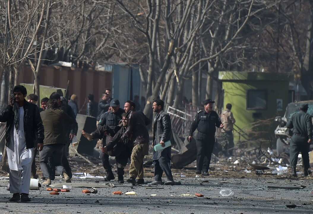 Afghan volunteers and policemen help the wounded.