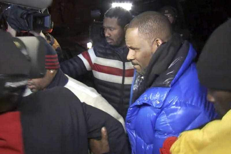 R. Kelly surrenders to authorities at Chicago First District police station, Friday.