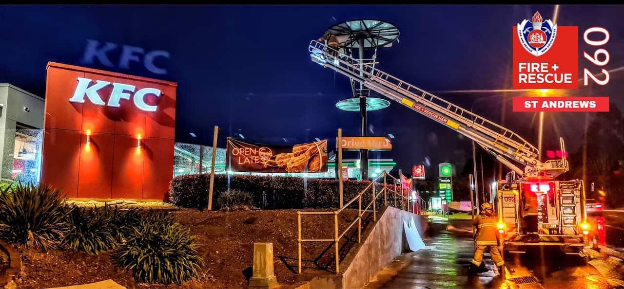 A fire engine with a large ladder was required to clear the scene after a large KFC bucket toppled over in the strong winds. 