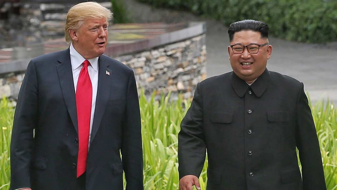 US President Donald J. Trump (L) and North Korean leader Kim Jong-un (R) stroll together through the grounds of the Capella Hotel in Singapore on 12/6/18.