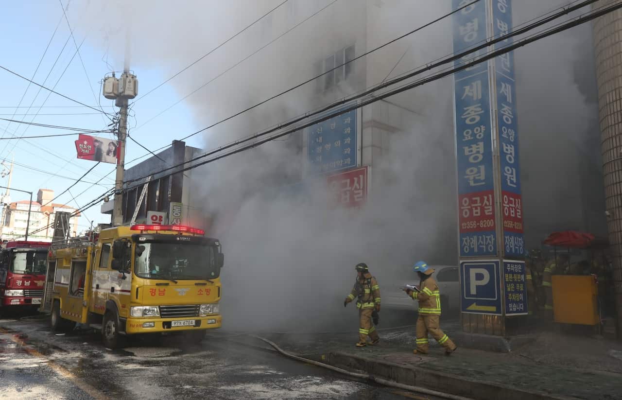 Firefighters try to put out a fire at a hospital in Miryang, southeastern South Korea, 26 January 2018.