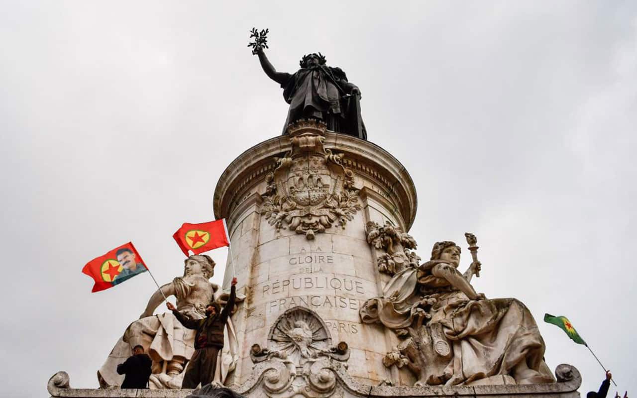 Demonstrators wave Kurdistan Worker's Party (PKK) flags on the statue of Marianne on the Place de la Republique during a demonstration in Paris.