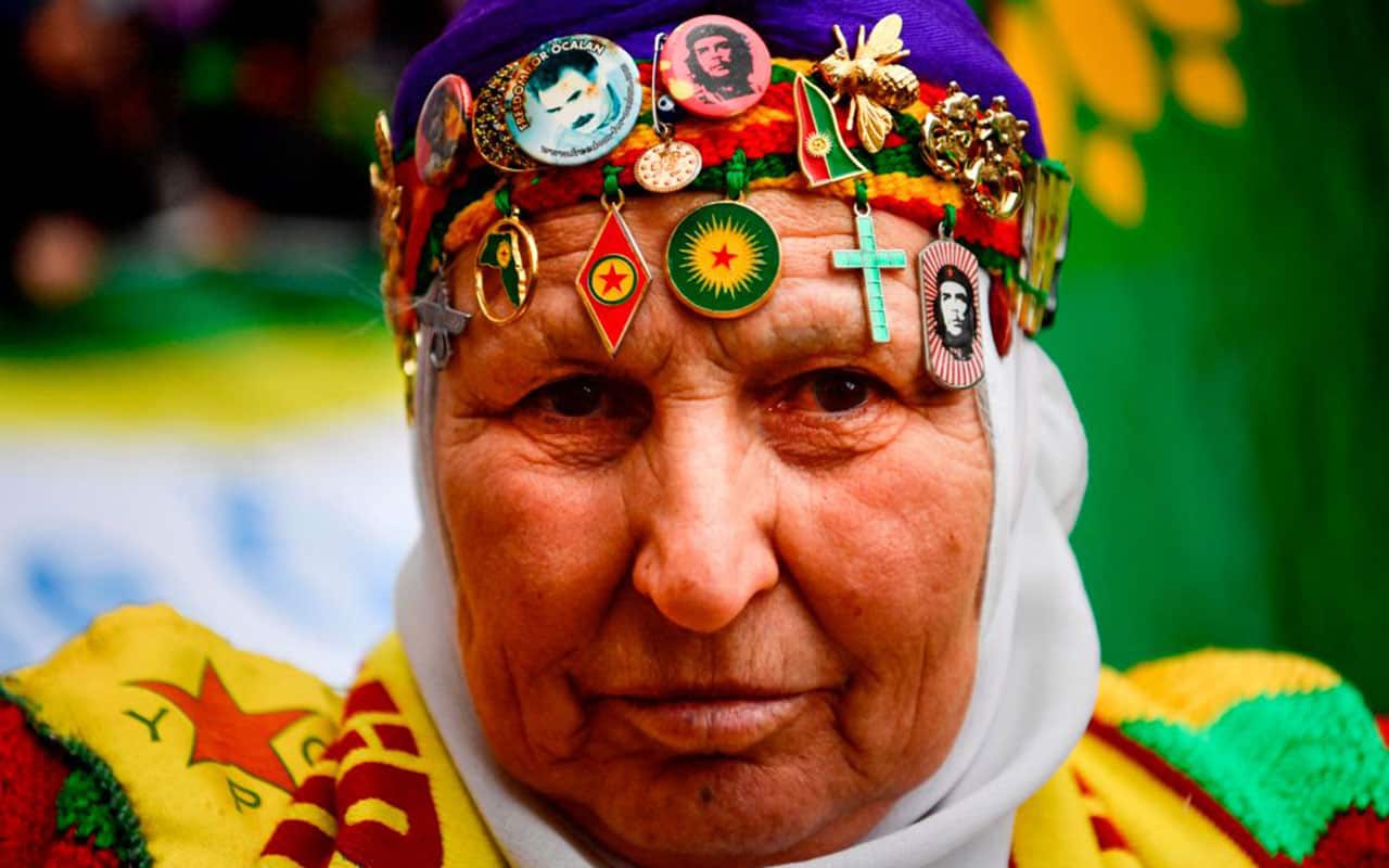 A Kurdish woman wearing Kurdish badges on her head, takes part in a demonstration in Paris on January 6, 2018, in tribute to the three Kurdish female activists.