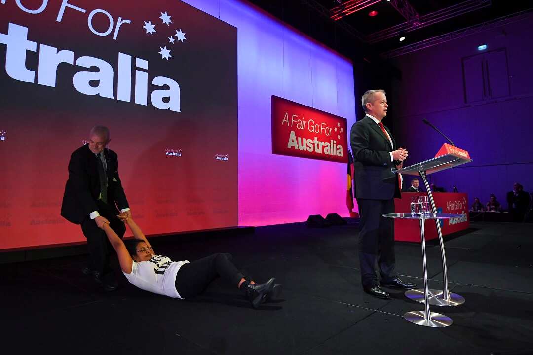 An 'Anti-Adani' protester is removed from stage as Australian Opposition leader Bill Shorten speaks.