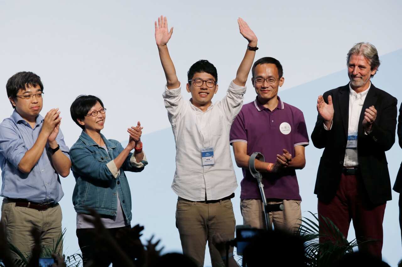 Student Nathan Law, center, who helped lead the 2014 protests, celebrates after winning a seat at the legislative council elections in Hong Kong (AAP)