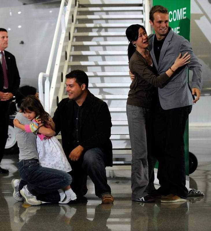 Journalists Laura Ling (2-R) and Euna Lee (L) arrive home to their families at Hangar 25 on 05 August 2009 in Burbank, California.