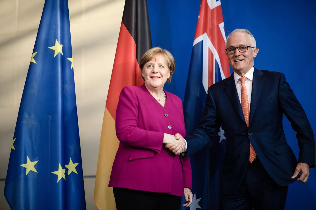 German Chancellor Angela Merkel (L) shakes hands with Australian Prime Minister Malcolm Turnbull (L) during a press statement at the Chancellery in Berlin