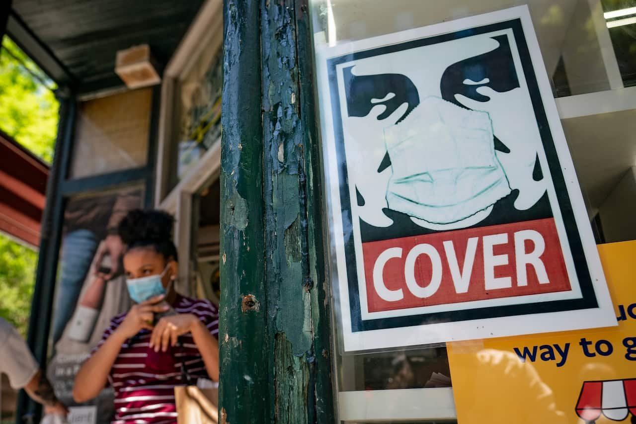 A customer exits a corner market while wearing a protective mask in the retail shopping district of the SoHo neighbourhood in the Manhattan borough of New York.