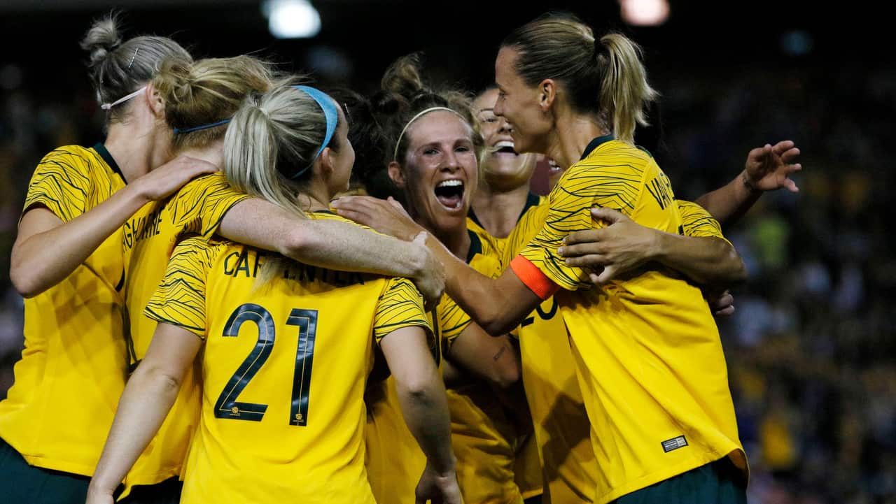 A group of Matildas players celebrate a goal.