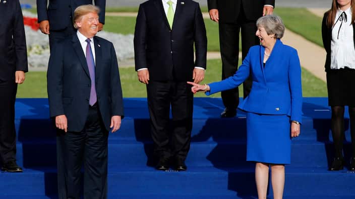 President Donald Trump and British Prime Minister Theresa May attend a group photo of NATO leaders. 