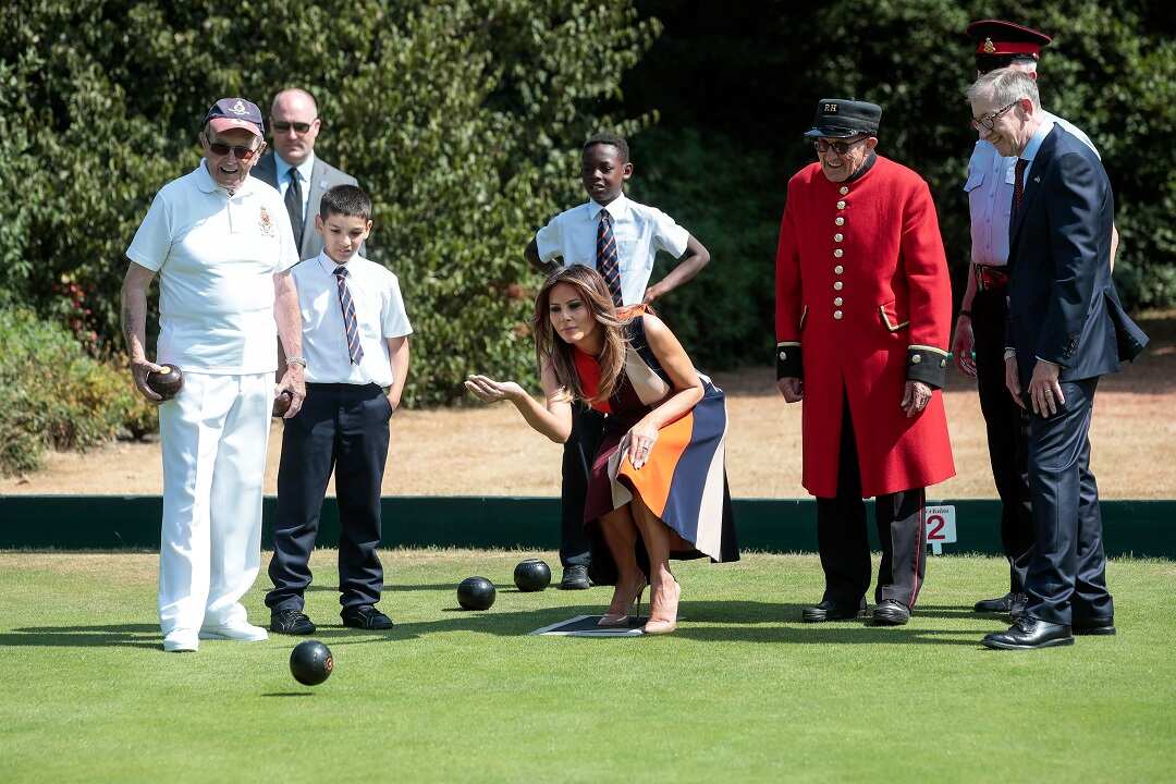 US First Lady Melania Trump tries her hand at lawn bowls as Philip May, right, husband of British Prime Minister Theresa May, watches on.