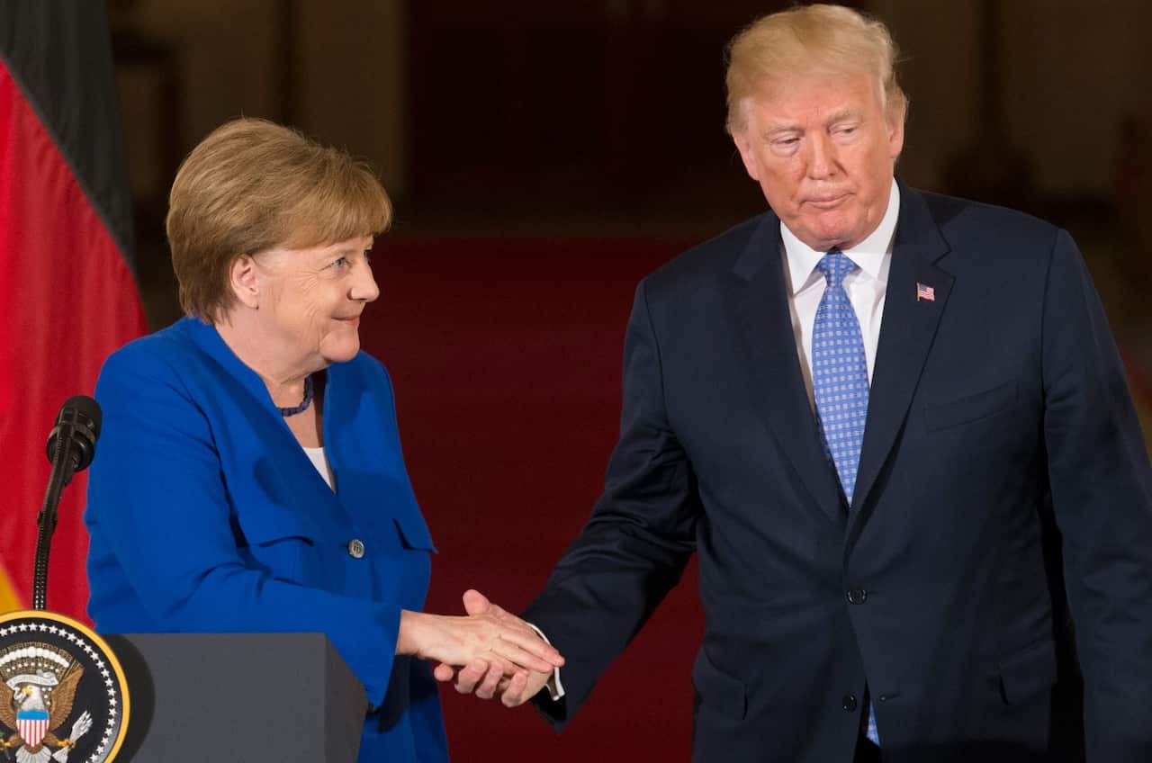 S President Donald J. Trump (R) and Chancellor of Germany Angela Merkel (L) shake hands while holding a joint news conference