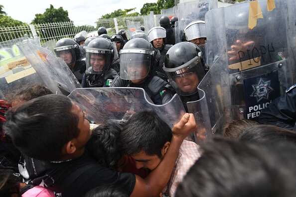 Mexican Federal Police officers try to prevent Honduran migrants from crossing the border.