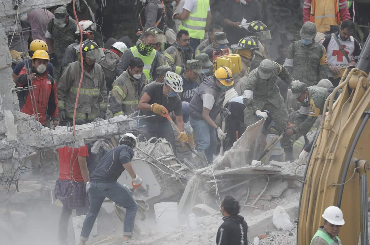 Rescue workers search in the debris of collapsed buildings in Mexico City, Mexico, 20 September 2017.