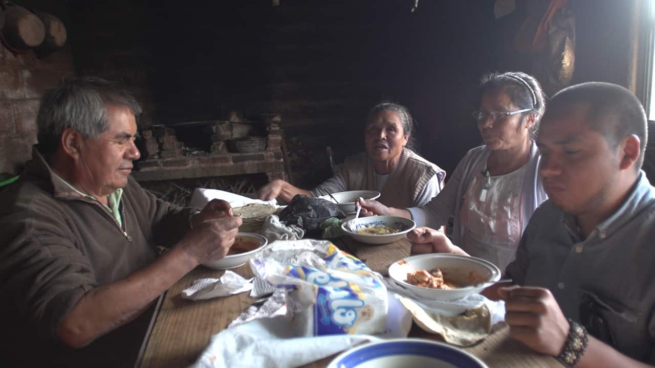 Aaron films - and eats - as Fidelia (second right) and her family enjoy their meal.