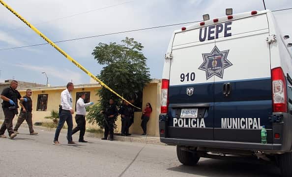 Forensic experts and police arrive at the crime scene, after the bodies of eleven people were found inside a house in Ciudad Juarez.
