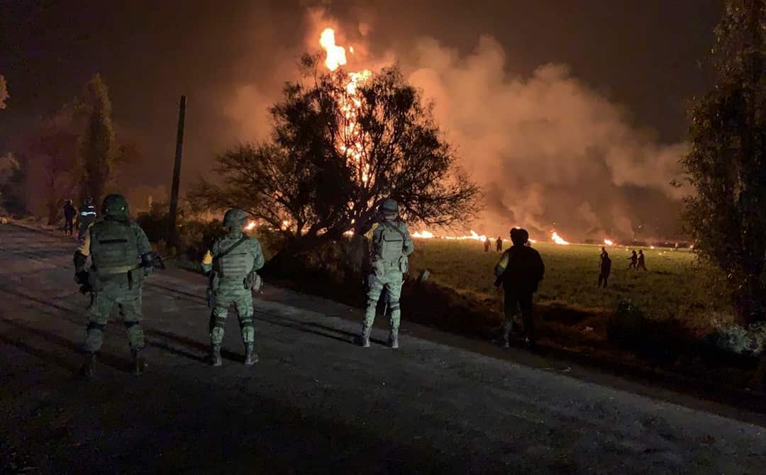 Soldiers guard the area where an explosion killed at least 66 people in Mexico.